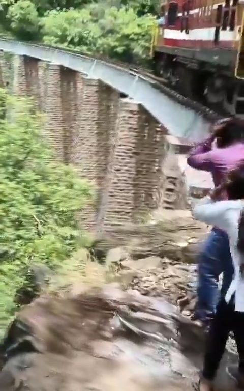 Sie machen Selfies auf der Brücke, als der Zug ankommt, und stürzen sich in einem schockierenden Video in die Schlucht